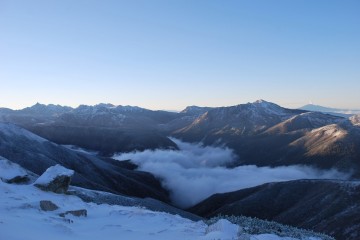 2400m以上が雪を被っています。　右端に、噴煙を上げている「御嶽山」遠望。