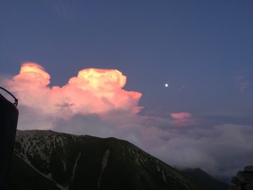 東南稜に掛かる夕照の雲間から月の出